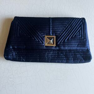 IN’s navy blue quilted clutch features distinctive geometric stitching and a cen